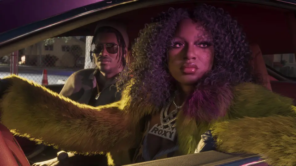 One of the Real Dimez in a fur coat, in the back of a car.